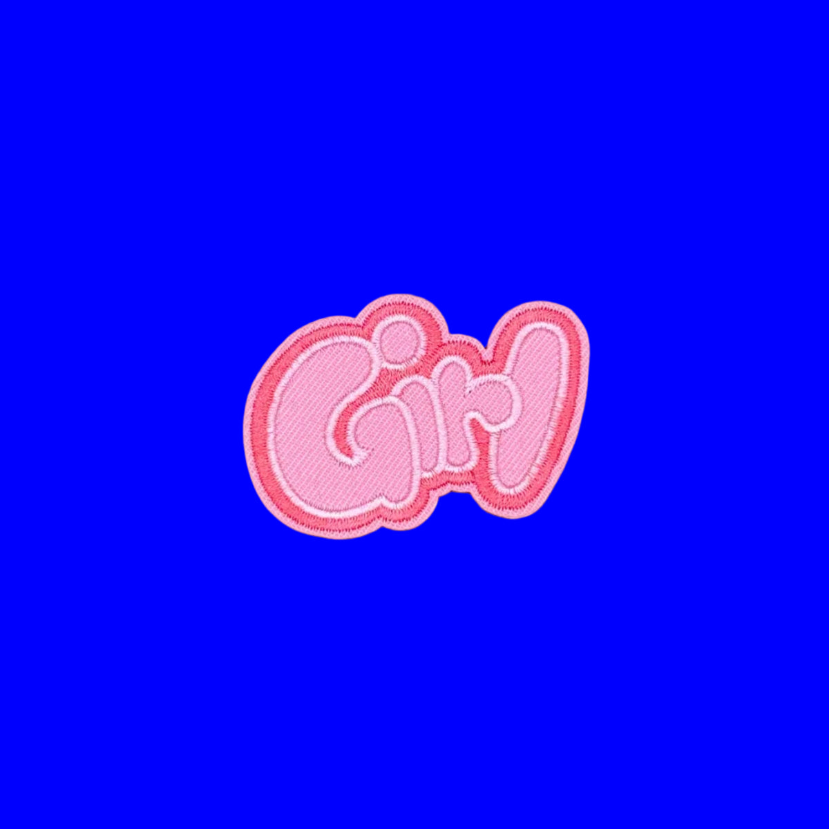 GIRL in graffiti text in pink letters embroidered iron-on patch on a blue background.