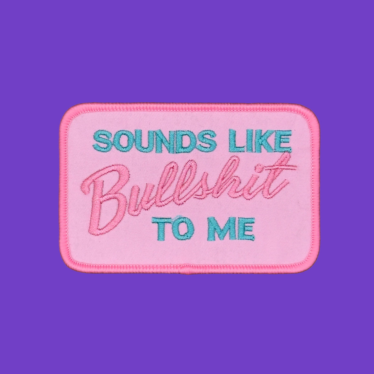 Sounds Like Bullshit To Me in teal and pink script on a pale pink background embroidered patch