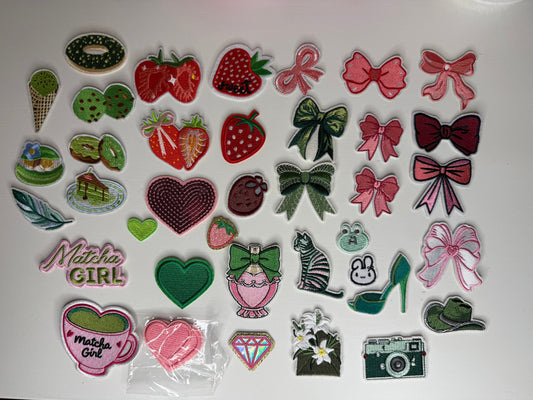 selection of pink and green and red iron on patches that could go on a canvas tote, jeans or hat. The patches are strawberries, small cute animals, bows, and matcha latte and matcha dessert patches