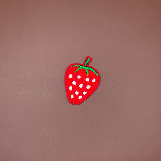Classic red strawberry iron-on patch with white seeds and a green leafy top