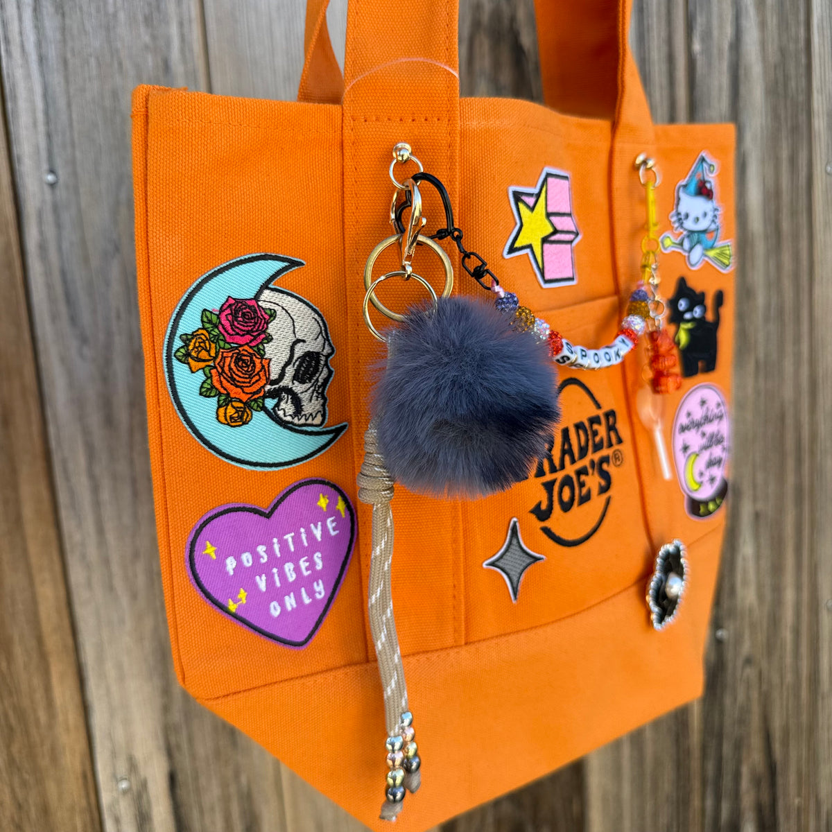 Detail of the custom Halloween Trader Joe's mini tote with spooky patches and charms