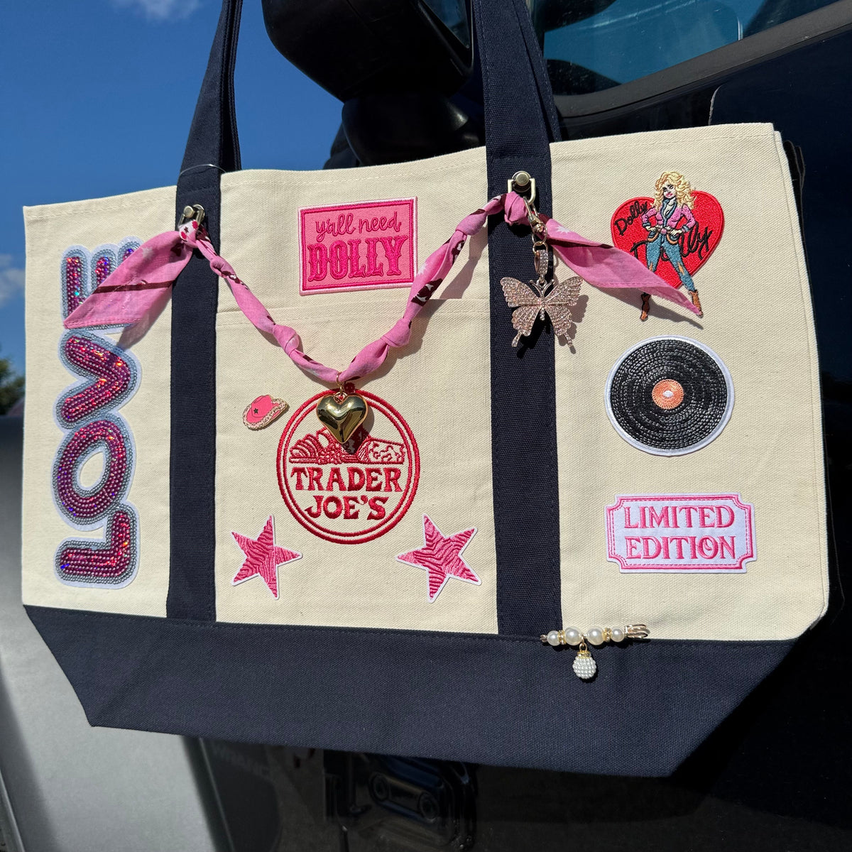 Dolly Limited Edition large custom tote by PrettyMUCH: navy Trader Joe's canvas bag with sequin LOVE patch, Dolly patches, pink bandana chain and butterfly charm