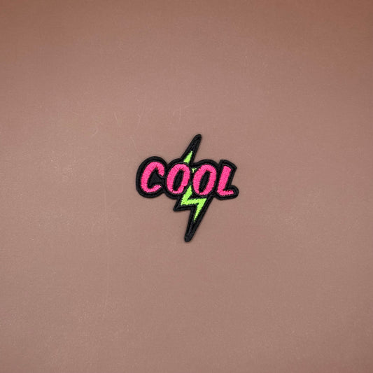 Iron-on patch with hot pink block letters on black and a neon green lightning bolt