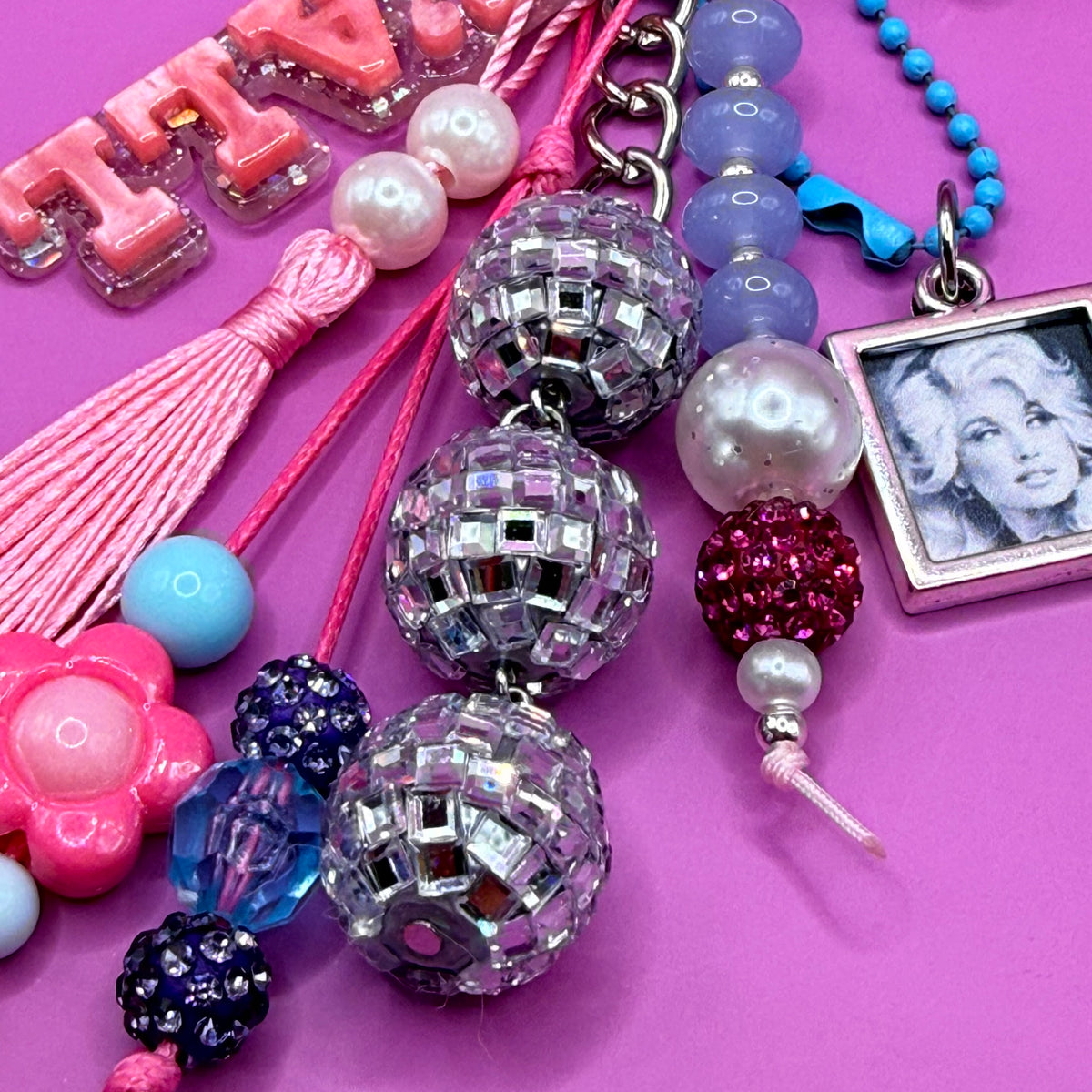 Detail of the 1-of-1 Y'all Disco Dolly bag charm by PrettyMUCH, with disco ball beads, lilac and rhinestone beads and pearls.