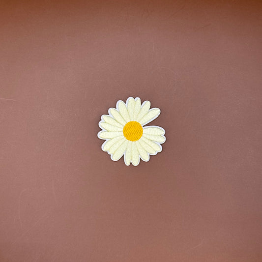 Ivory daisy embroidered iron-on patch with a yellow center