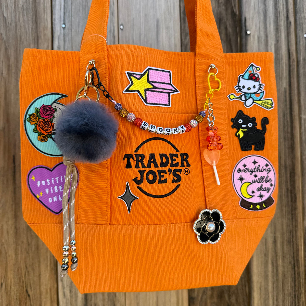 Halloween Trader Joe's mini tote tricked out with spooky patches, a beaded SPOOKY bag chain and candy charms