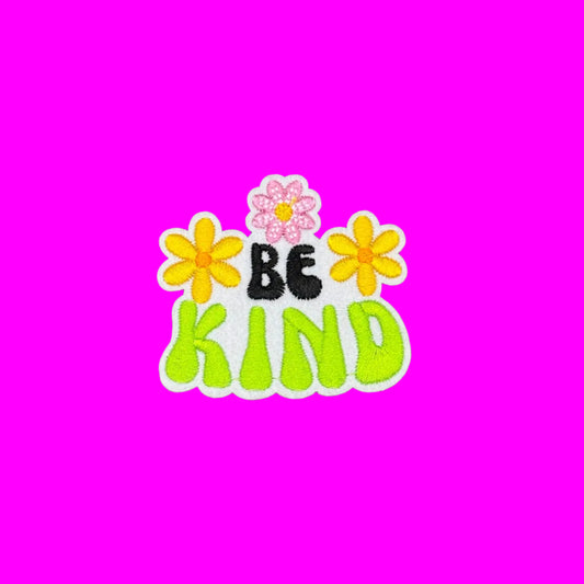 Be Kind iron-on patch in black and lime bubble letters framed by yellow and pink daisies