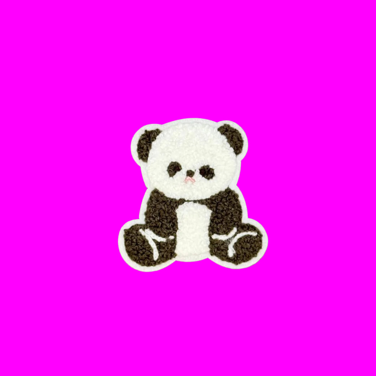 A small embroidered panda patch with a white body and black ears, eyes, and limbs, centered on a smooth brown background.