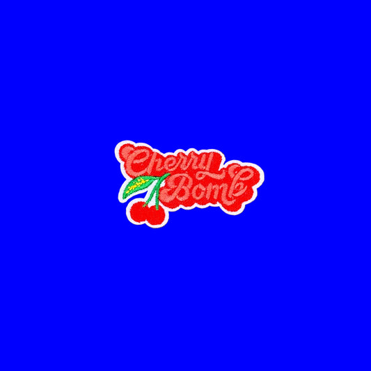 Red retro Cherry Bomb script iron-on patch with a pair of cherries hanging off the front