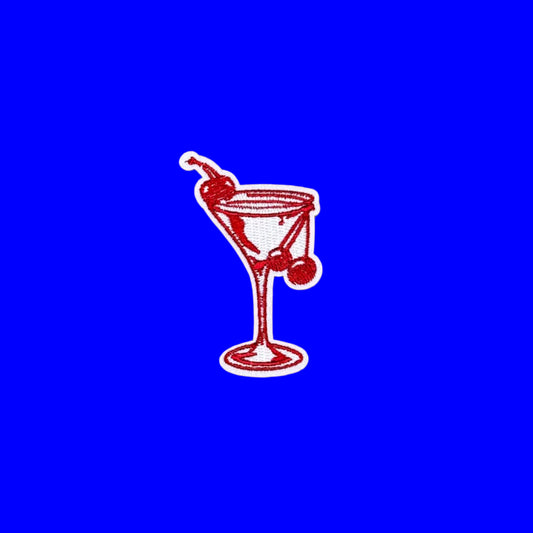 Iron-on patch of a cocktail glass outlined in red with two cherries on the rim