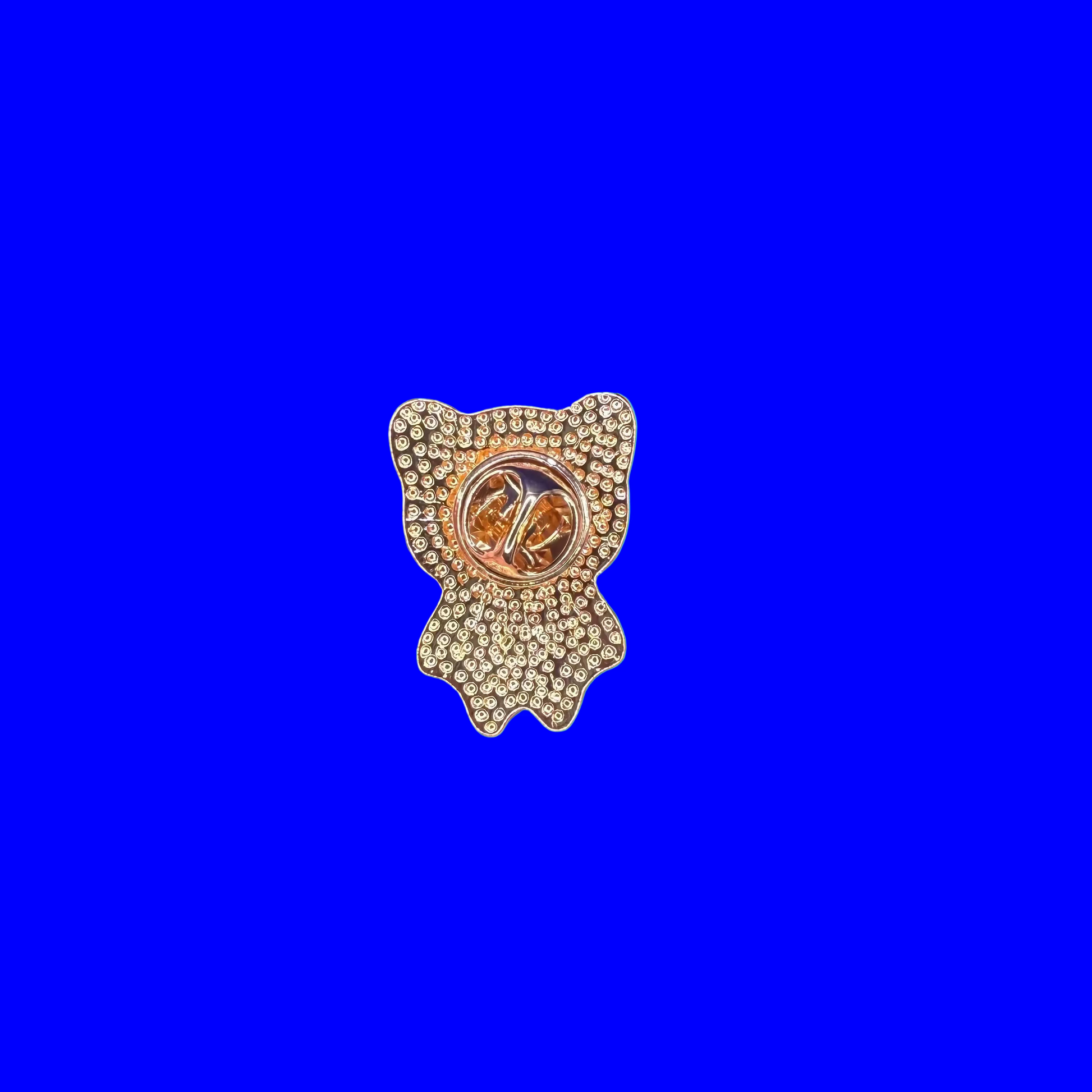 Back of the wide-eyed panda enamel pin showing the gold metal back, on a blue background