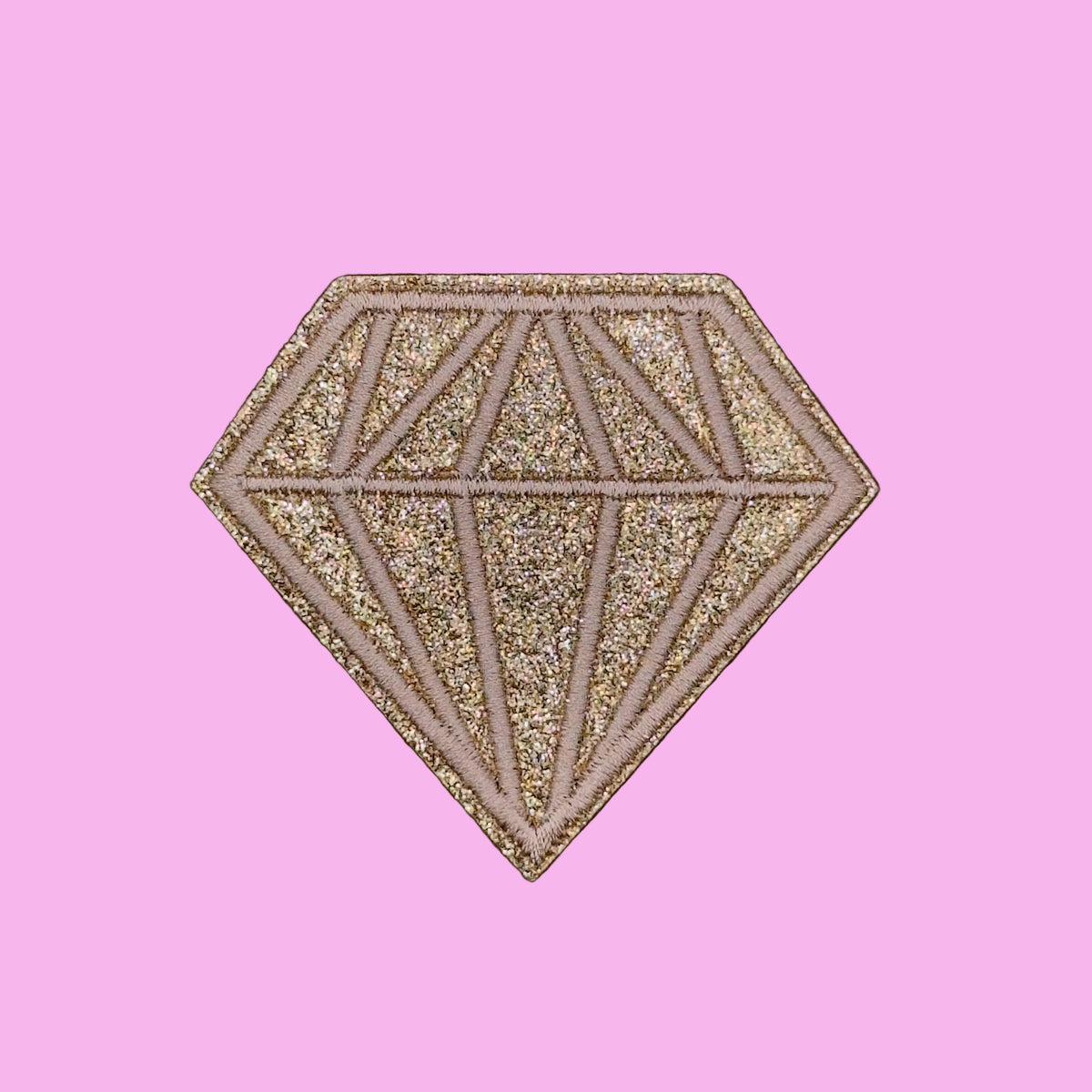 A glittery diamond-shaped patch with a faceted gemstone design, featuring a textured gold and rose gold glitter finish on a solid brown background.