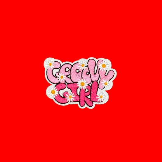 'Groovy Girl' iron-on patch with two-tone pink bubble letters and small white daisies