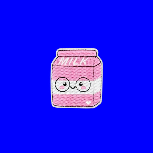A pink embroidered patch shaped like a milk carton with a cute cartoon face, shown on a solid blue background.