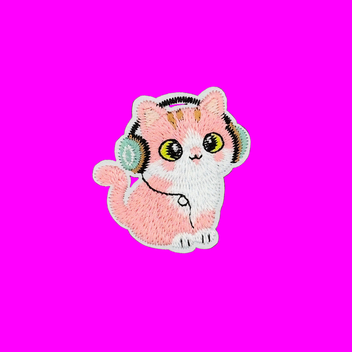 A pink and white embroidered patch of a cute cat wearing headphones.