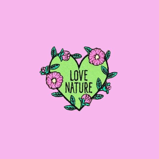 Lime green heart iron-on patch wrapped in a vine of pink blooms and teal leaves. Black 'Love Nature' in script. 