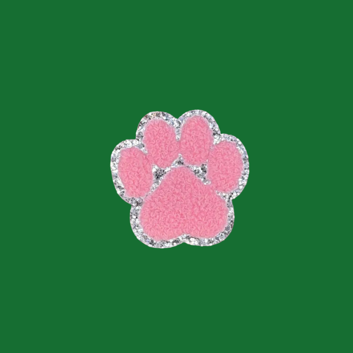 A pink paw print charm with a silver glitter border, centered on a brown textured background.