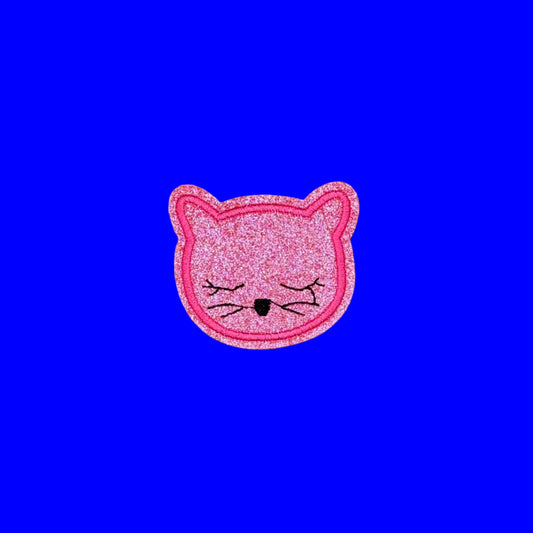 Pink glitter cat face iron-on patch with lashes down and a small black nose