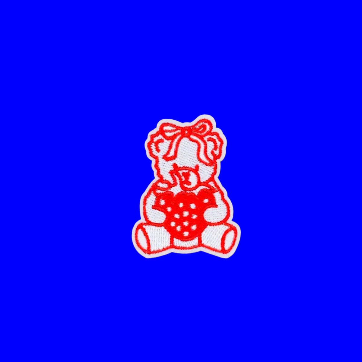 Red outlined teddy bear with bow holding a strawberry embroidered iron-on patch.