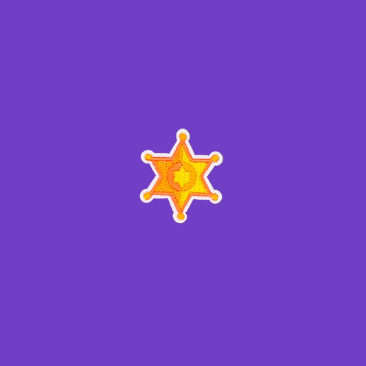A small sheriff's badge shaped sticker or decal in orange, yellow, and white, centered on a solid brown background.