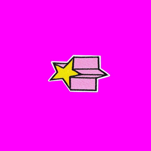 Yellow shooting star iron-on patch cutting across a pink trail outlined in black