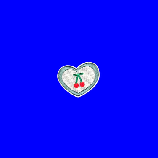 Sage-bordered heart iron-on patch with a cream center and two red cherries