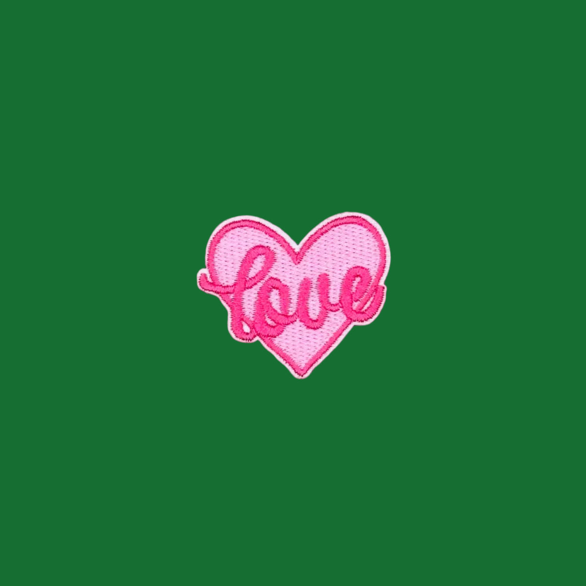 Pink heart with 'love' written across the heart embroidered patch.