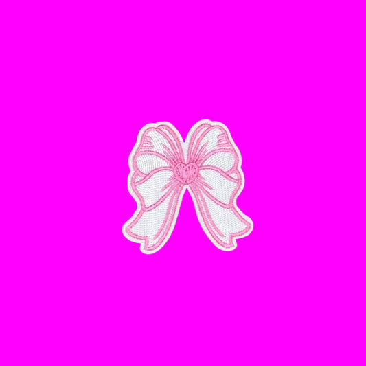 A pink and white embroidered bow patch with a white border, centered on a solid brown background.