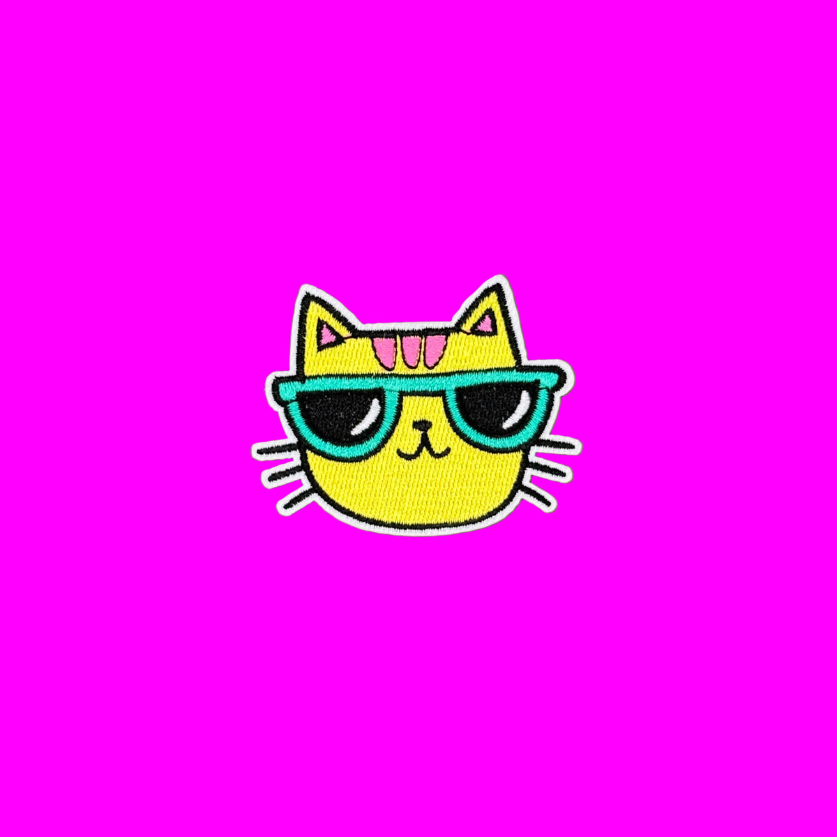 Yellow cool cat with pink stripes and teal colored sunglasses and black whiskers embroidered iron-on patch.
