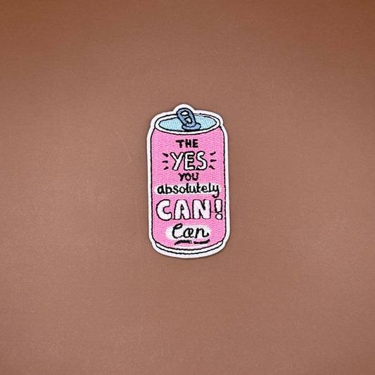 Pink soda can iron-on patch cracked open, reading “The Yes You Absolutely Can”