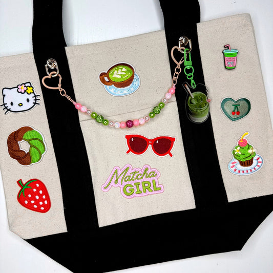 Official Matcha Fest tote in black with Matcha Girl patches, pins and beaded bag chain